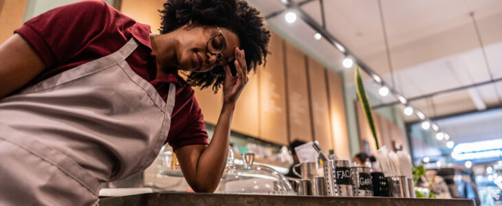 Worried young waitress working at cafeteria