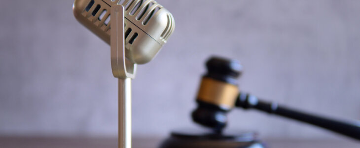 Closeup image of microphone and judge gavel. Entertainment law concept.