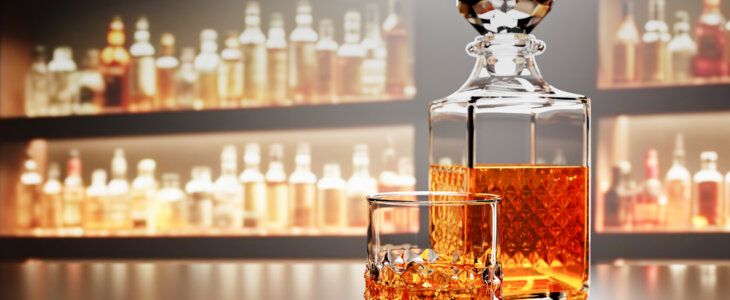 Whiskey or brandy, alcoholic beverages In transparent elegant bottle in Bar. Alcohol in clear glass on wooden floor table. Multiple wine bottles blur background On bar counter restaurant 3D RenderingWhiskey or brandy, alcoholic beverages In transparent elegant glass. Alcohol in clear glass on wooden floor table. On bar counter restaurant 3D Rendering